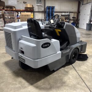 An Advance Exterra Ride-On Sweeper in a warehouse showroom at ChemSource Direct.