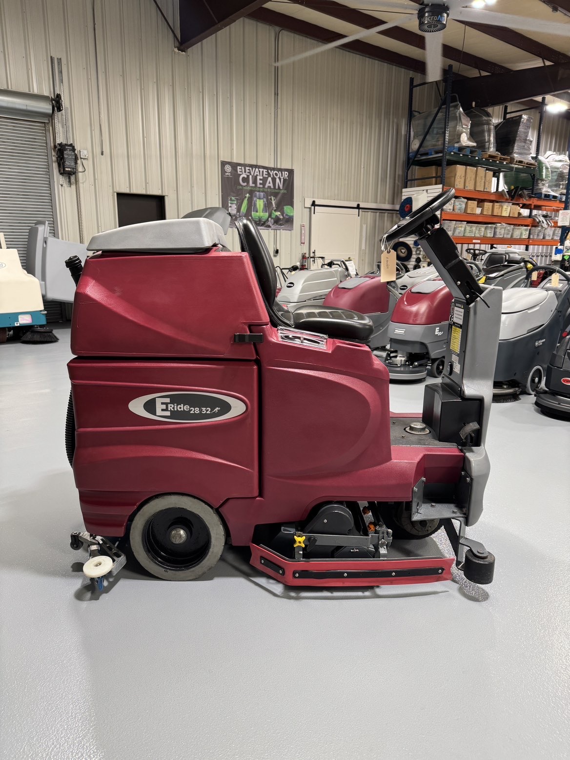 A Minuteman ERide 28/32 Cylindrical Ride-On Scrubber in a warehouse showroom at ChemSource Direct.